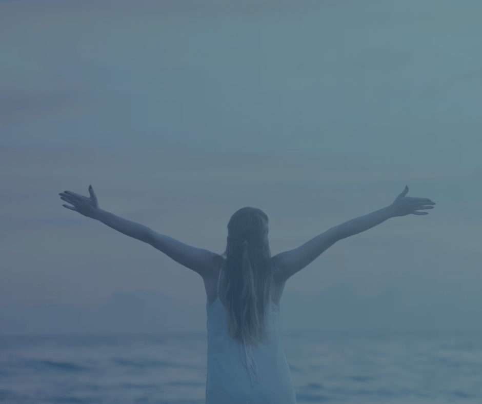 Girl on the beach holding out her arms.