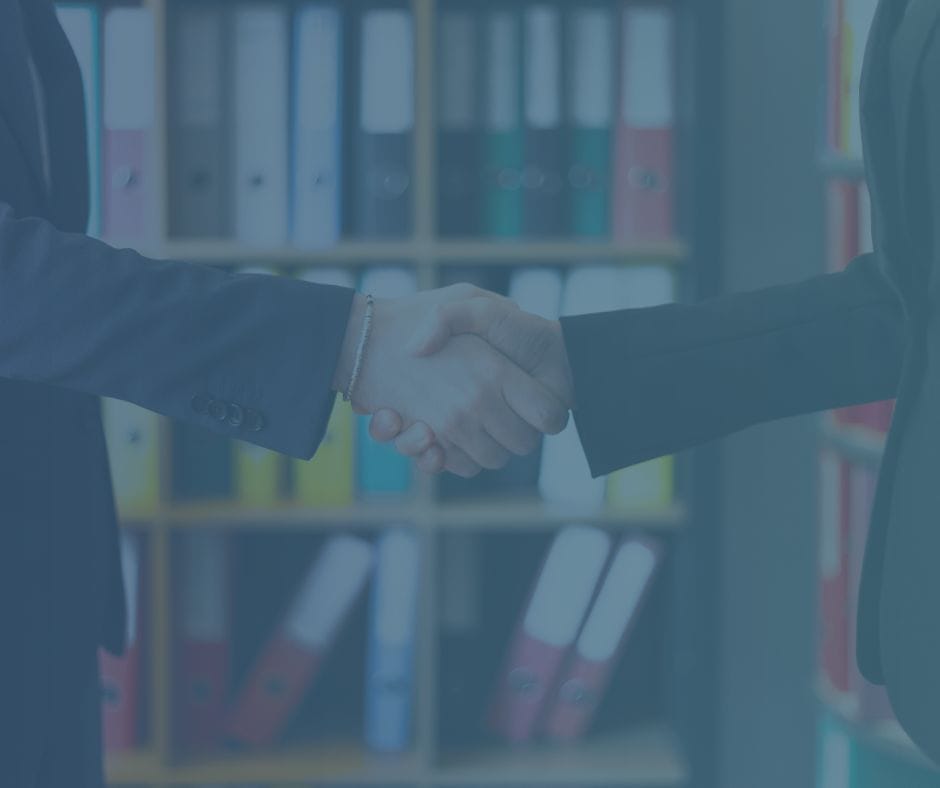 An interviewer and interviewee shaking hands.
